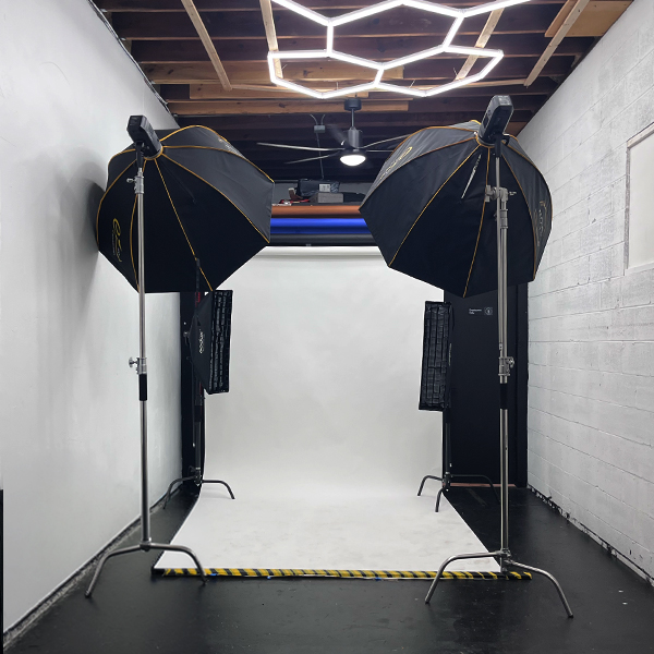 Studio B with white seamless backdrop, studio lights and geometric ceiling lights